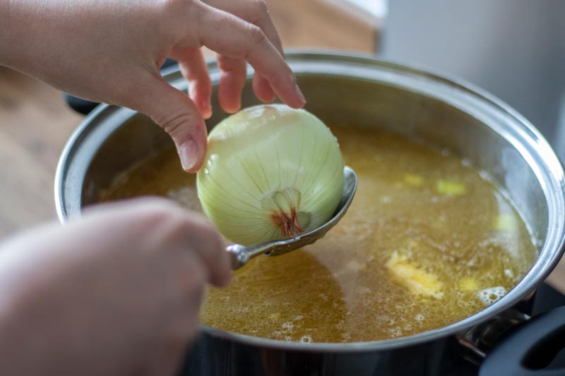 Onion being put into soup