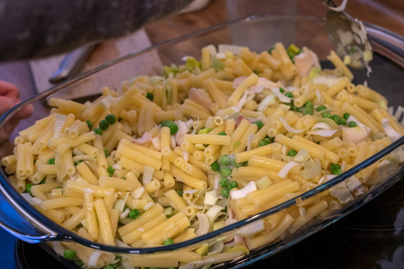 Pasta, fish, peas and leek mixed together in the dish